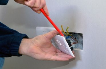 The hands of an electrician installing a power socket, perfect for a blog about the cost to get new power points installed