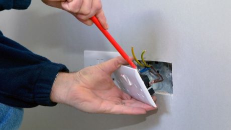 The hands of an electrician installing a power socket, perfect for a blog about the cost to get new power points installed